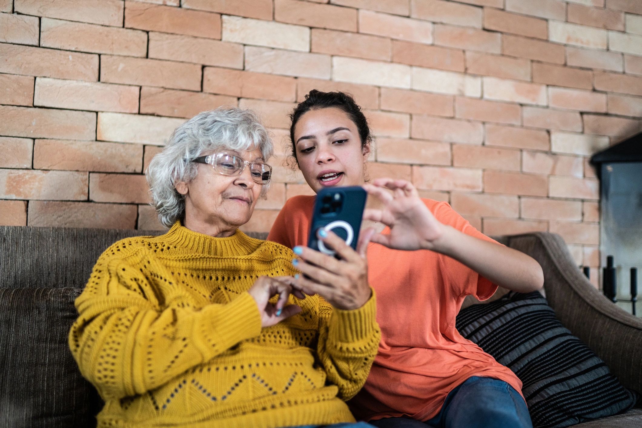 Tech helper showing an older adult how to use a smartphone