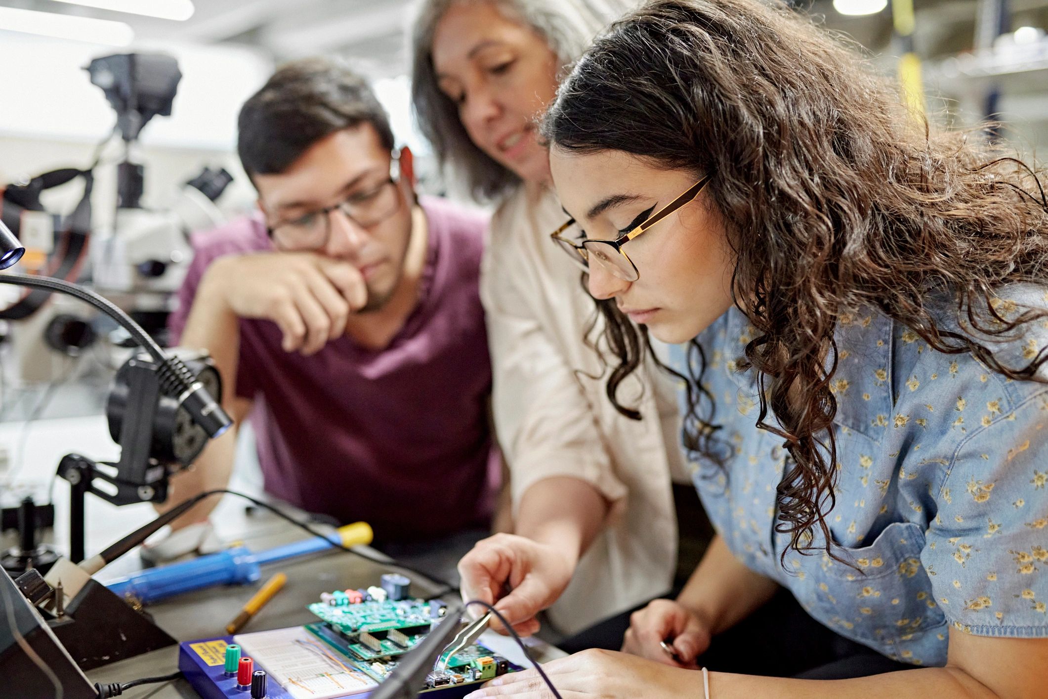 Instructor assisting learners during a hands-on tech workshop